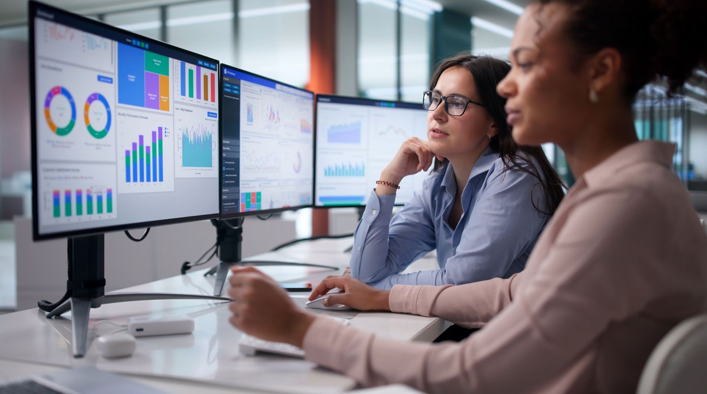 Data analyst homme analysant dashboard business intelligence en français sur grand écran courbe, bureau lumineux contemporain Luxembourg avec graphiques colorés KPI et carte Europe, lumière naturelle fenêtre